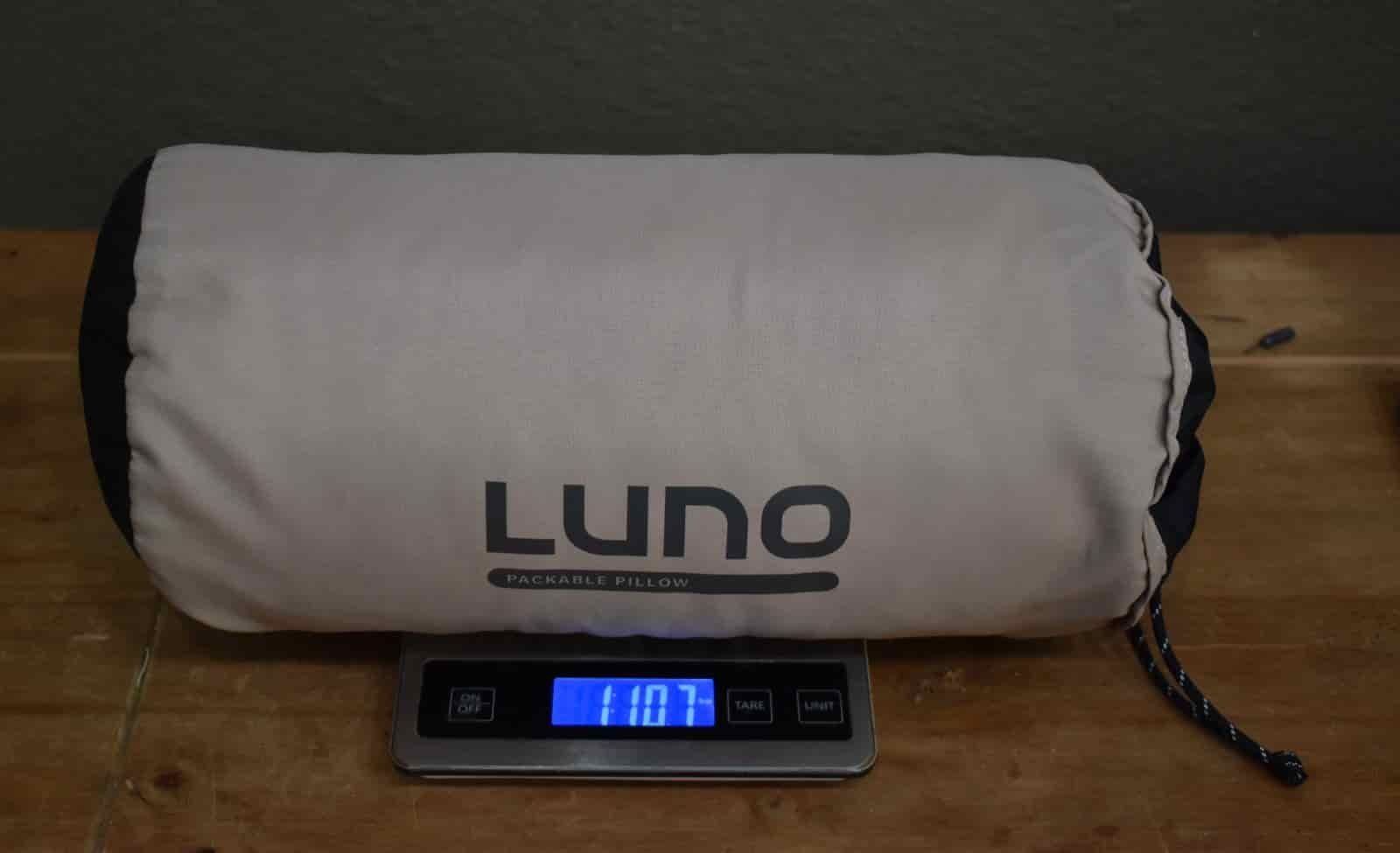 pillow in a stuff sack on a kitchen scale that reads 1 lb 11 oz