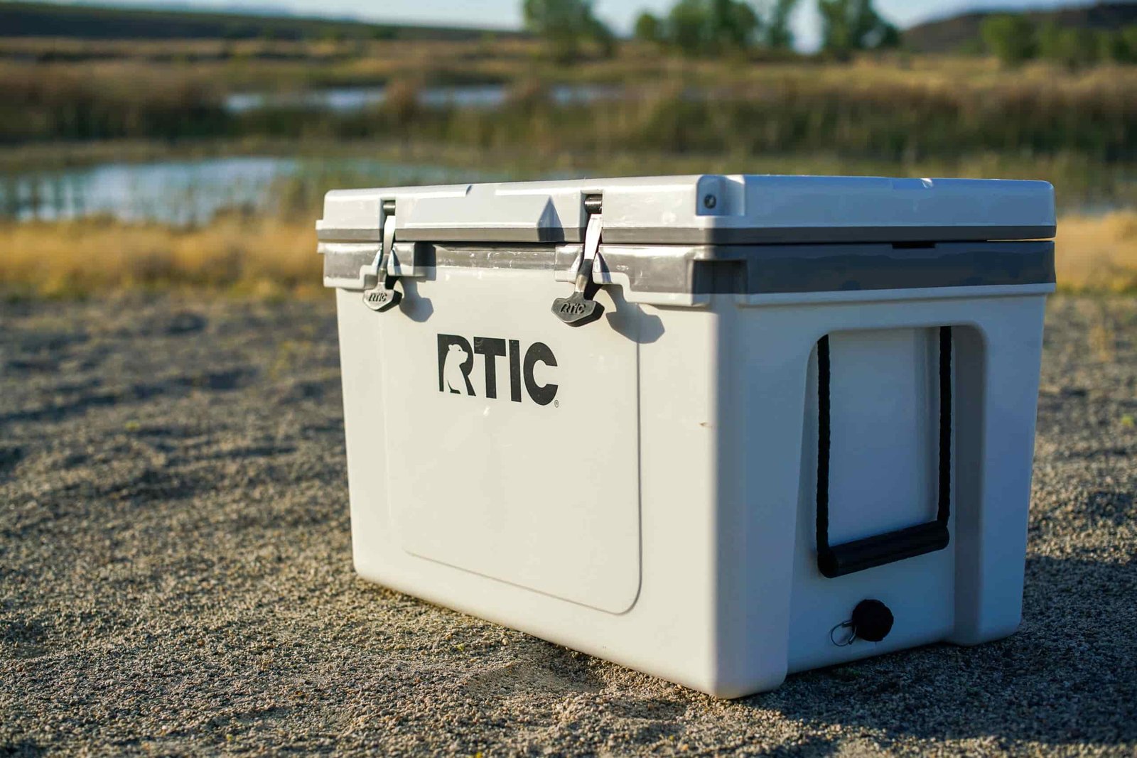 The RTIC Ultralight 52 sits on sandy ground with a body of water in the background.