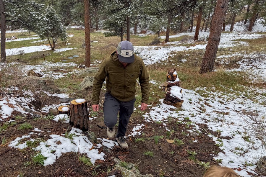 Hiker ascending a lightly snow-covered slope wearing Keen Hightrail Mid boots.