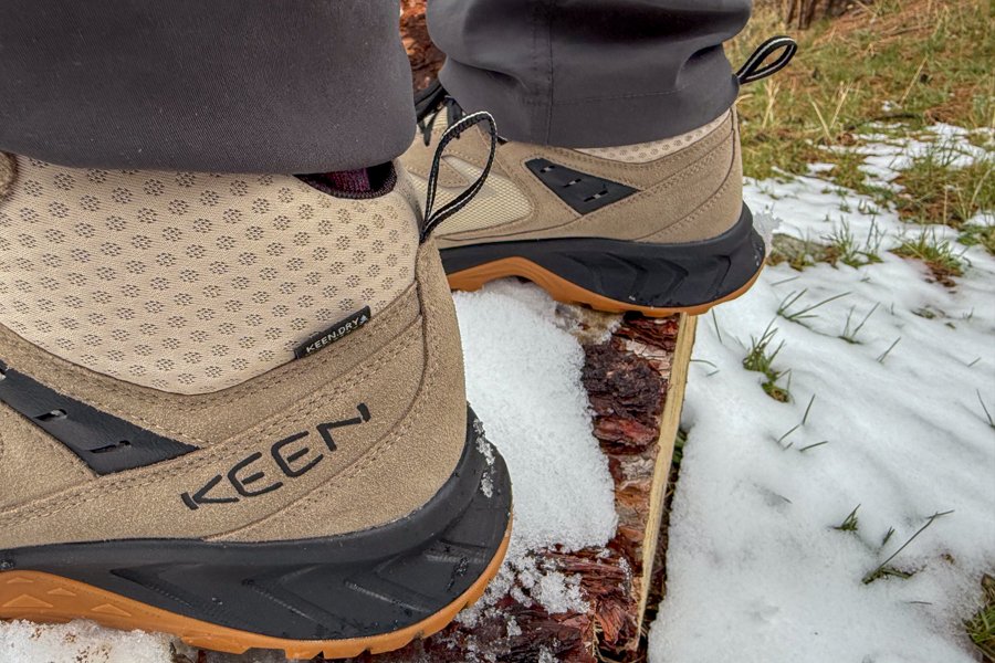 Side view of Keen Hightrail Mid boot on a snow-dusted log, showing upper materials and midsole.