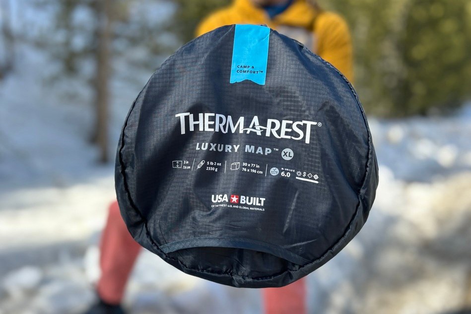 Up-close image of the top of a camping mattress in its stuff sack with logos visible.