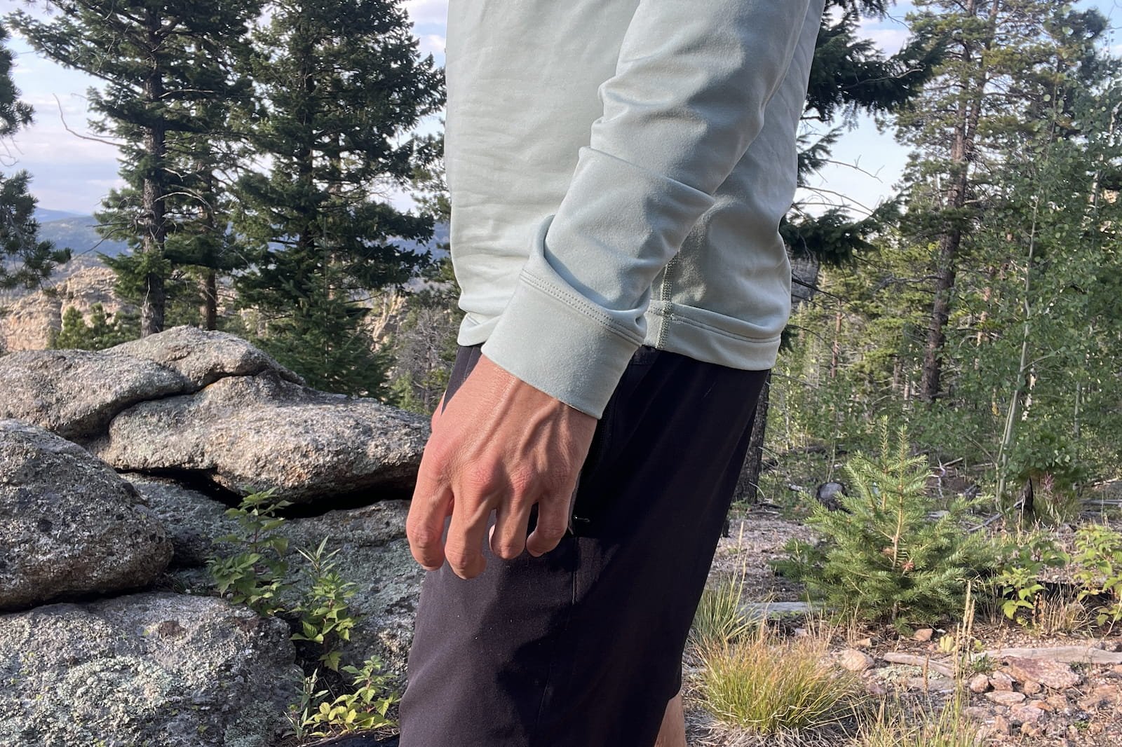 a closeup profile from chest to knees of a hiker wearing a light blue base layer.