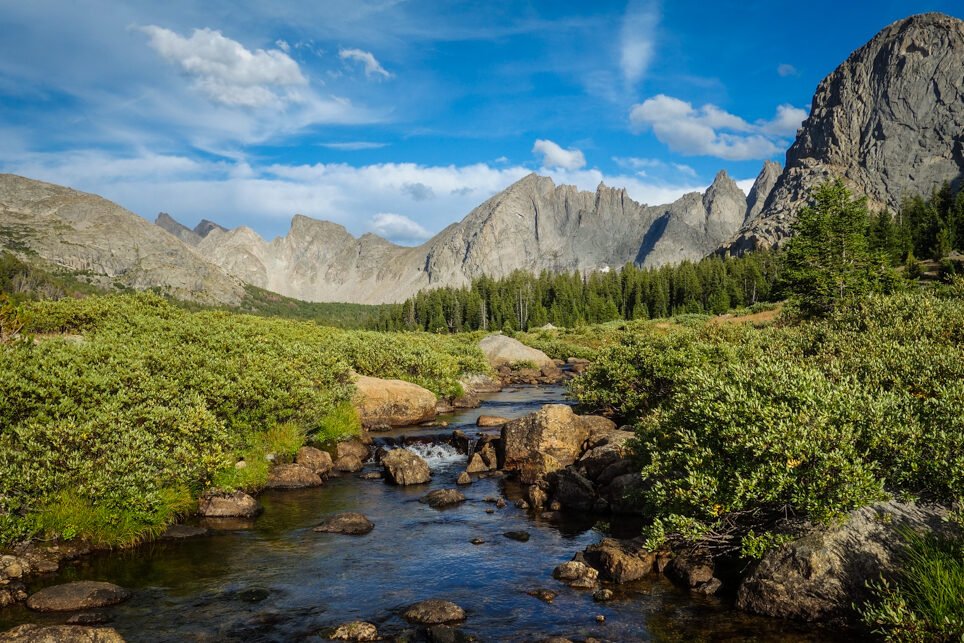 a river running down from granite mountains on the cirque of the towers backpacking loop