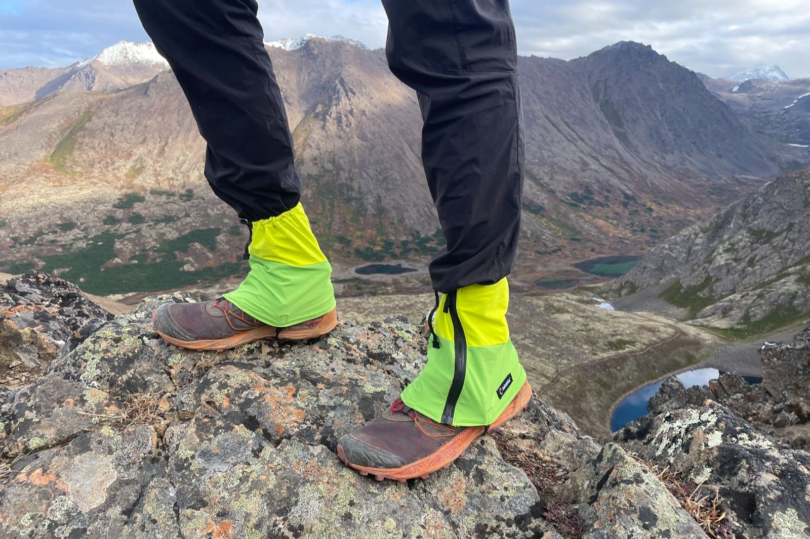 A closeup of hikng giaters with a mountainous background.