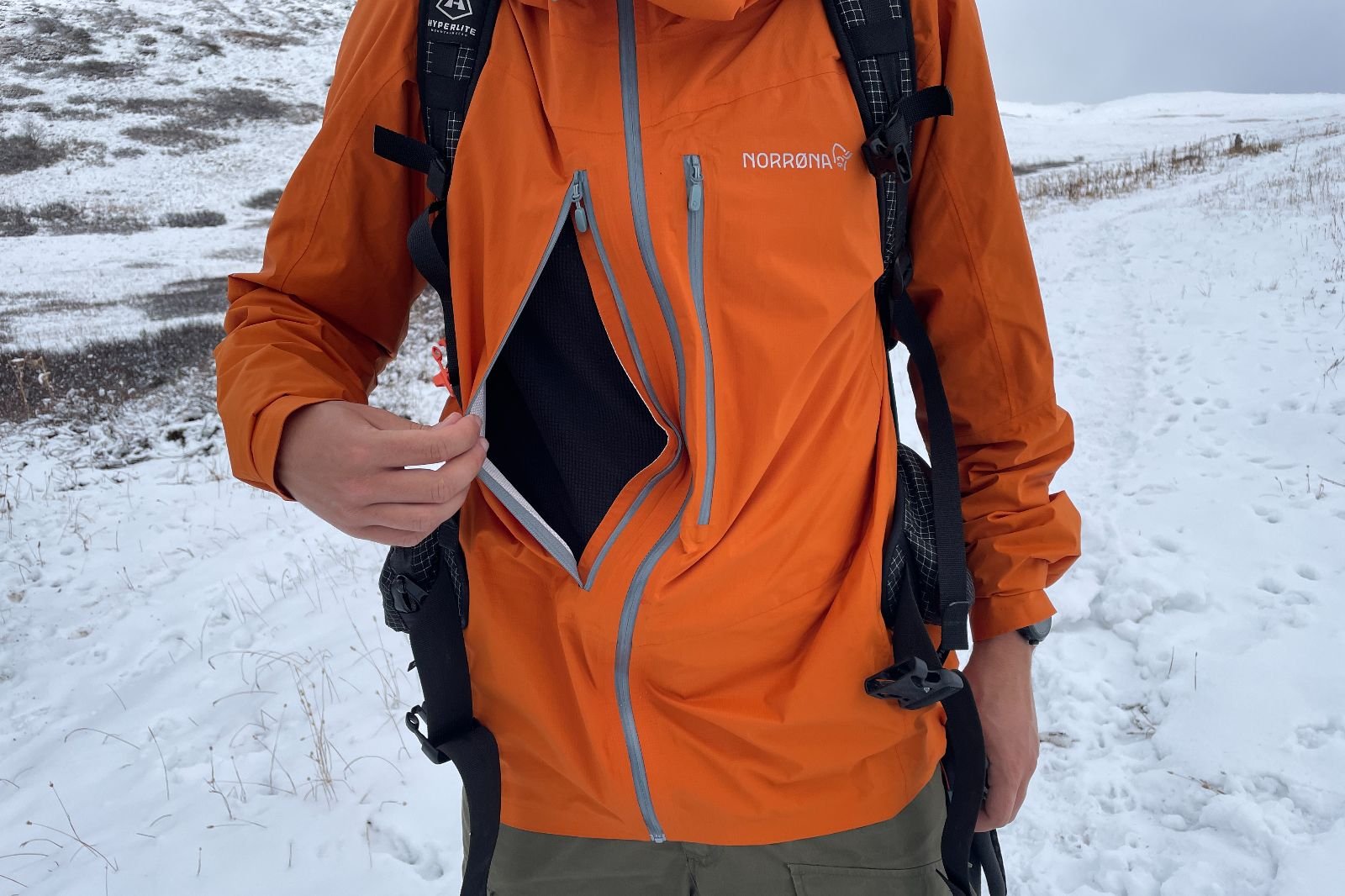 A closeup of the chest vent opened on an orange rain jacket.