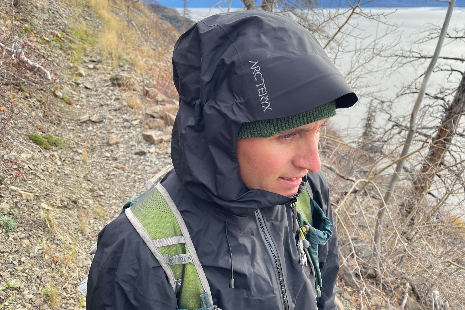 A closeup of the hood and logo of a black rain jacket.