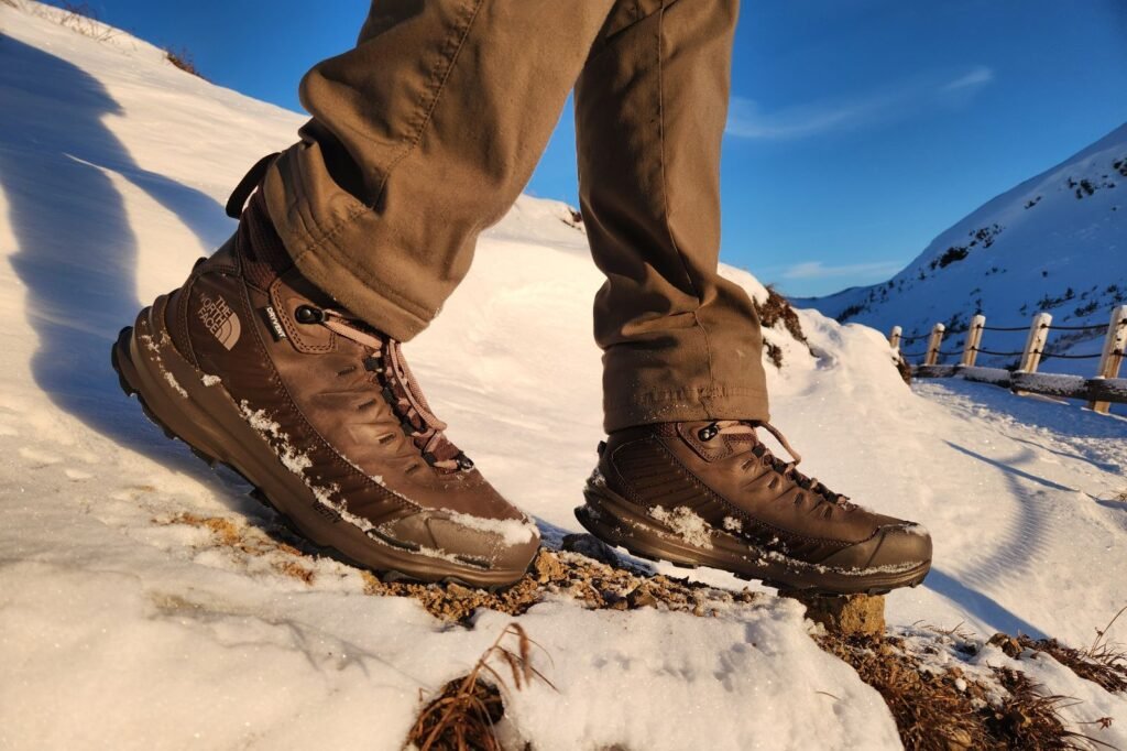 A closeup of boots walking down a winter landscape.