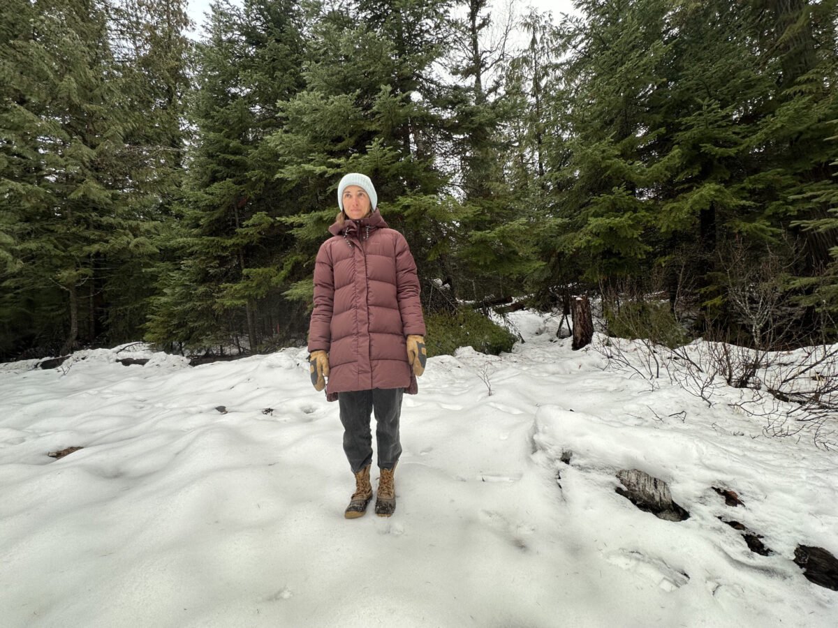 women in a down parka in a snowy forest
